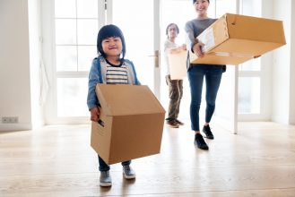 Child Moving Boxes into New Home